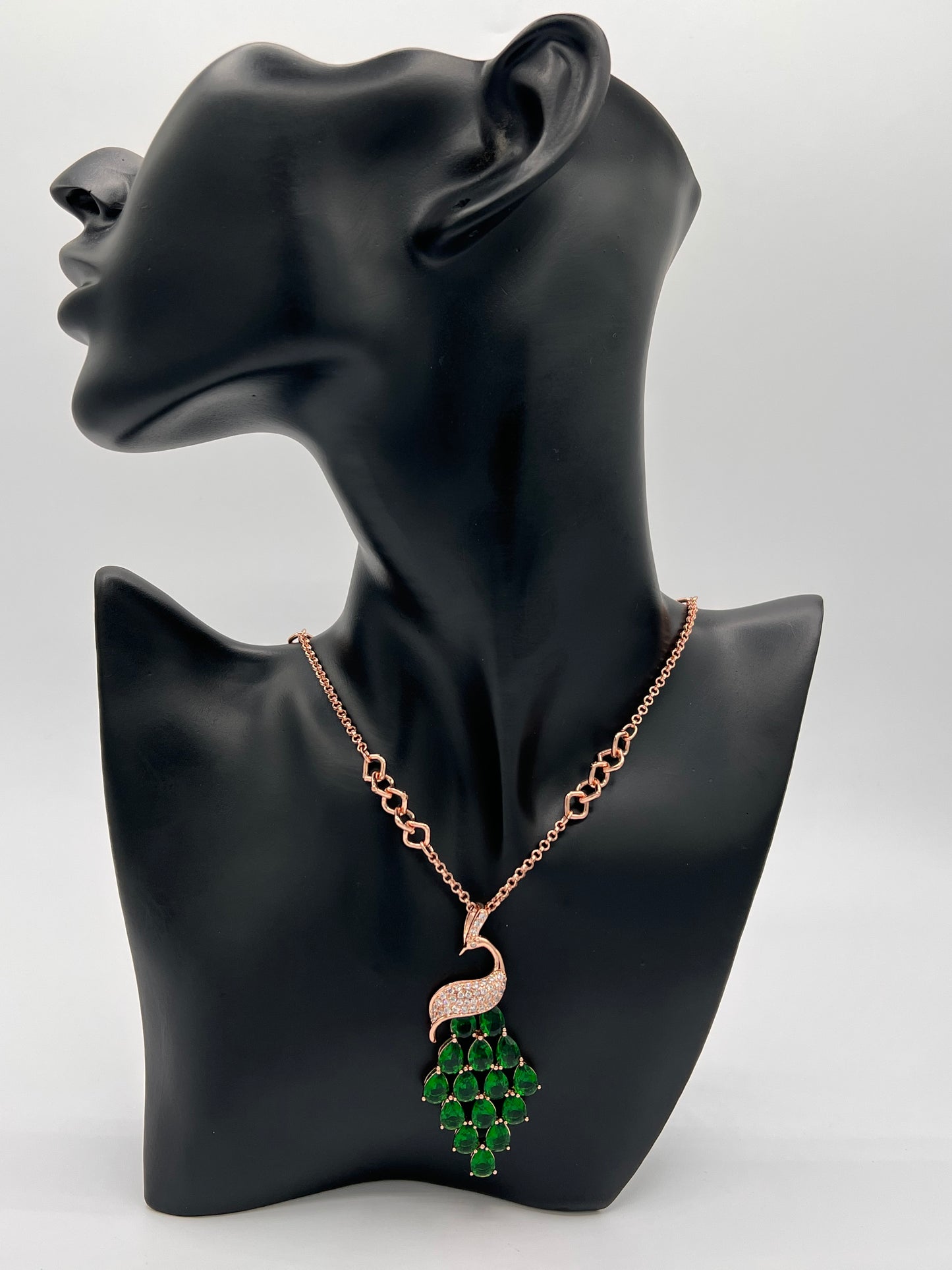 rose gold 70cm chain with peacock design pendant. the peacock body is embellished with with cubic zircons and the feathers are made of big tear shaped green cubic zircons the link chain has small and big links which give this chain a unique look .suitable to wear with any dress or sweater or with hijab