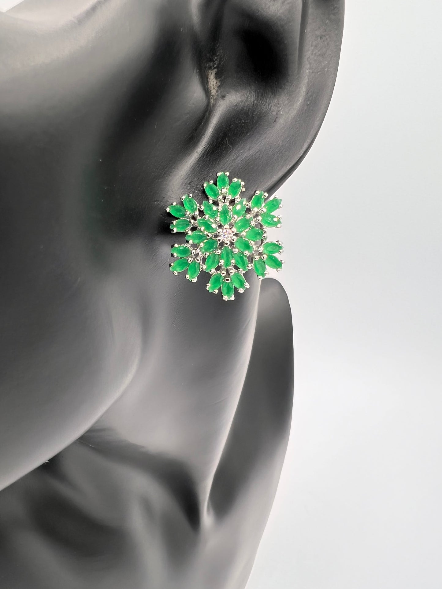 emerald green snow flake design studs earrings embellished with man made emeralds